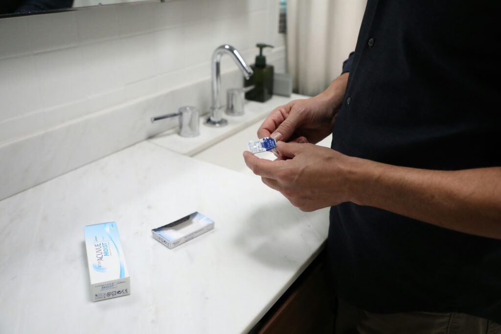 Choosing contact lenses online uk. man putting in conatct lenses