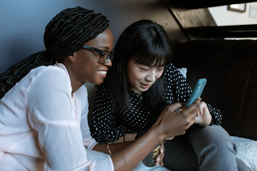 fat joe stock image, two women looking at a phone