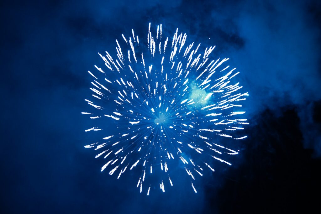 A blue firework bursting in the night sky
